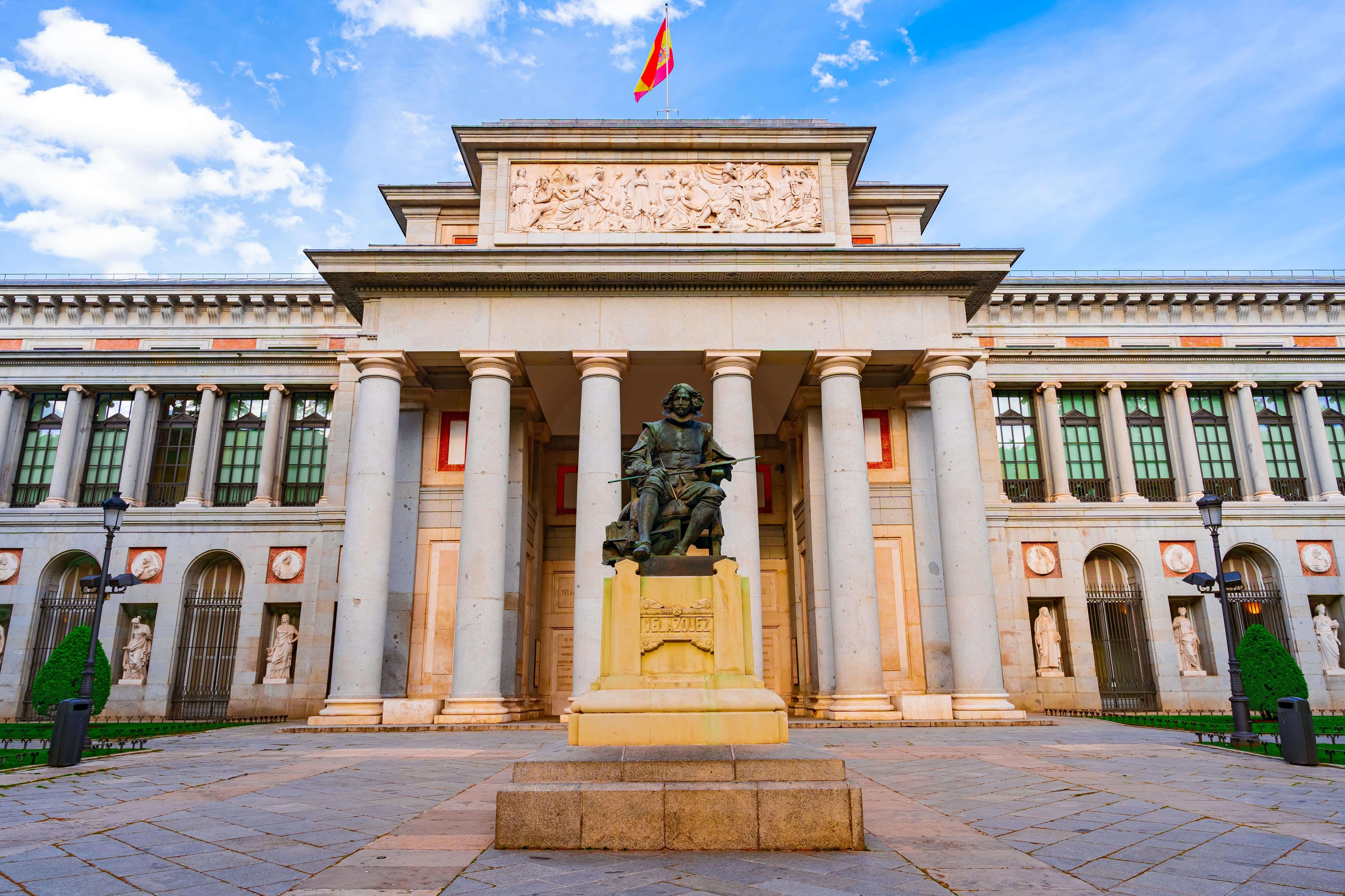 Entrance to the Prado Museum in Madrid at this time, a sunny day with blue skies and clouds.